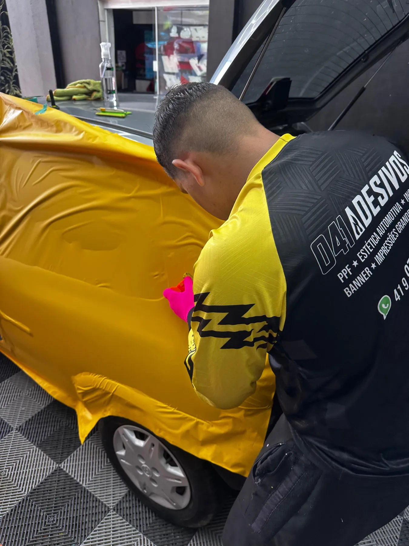 Aplicador da 041 envelopando hatch em vinil amarelo