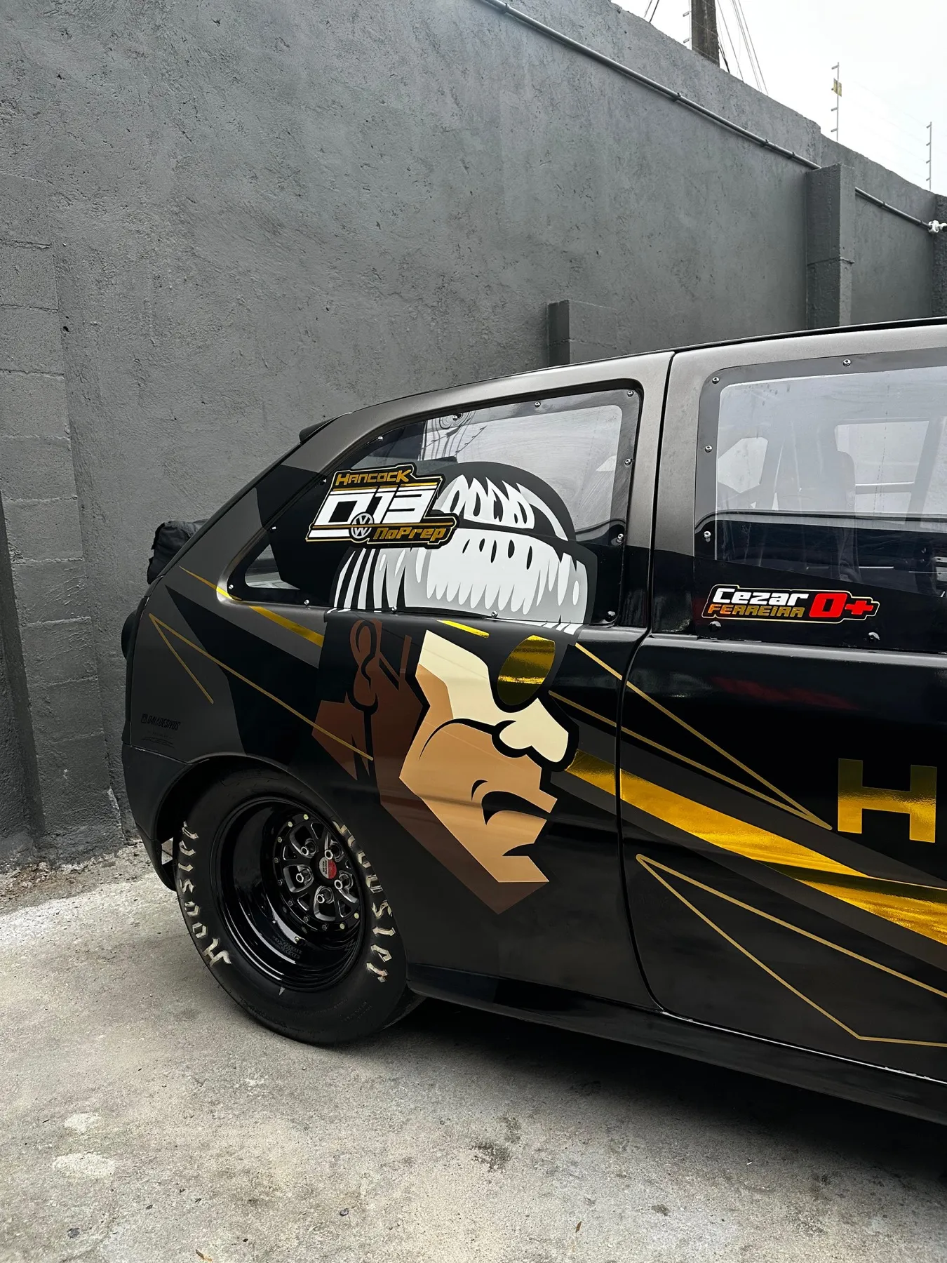 Hatch preto envelopado com arte dourada de barbearia