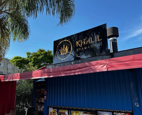 Fachada do Khalil Shawarmas com letreiro preto e dourado