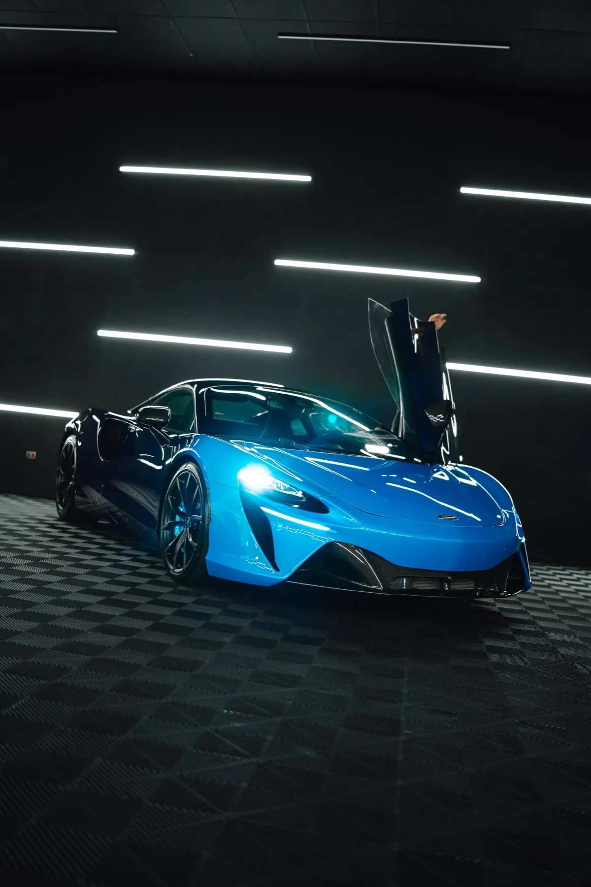McLaren azul com portas tesoura abertas em estúdio