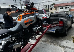 Moto trail com tanque Adrenalina sendo carregada em guincho
