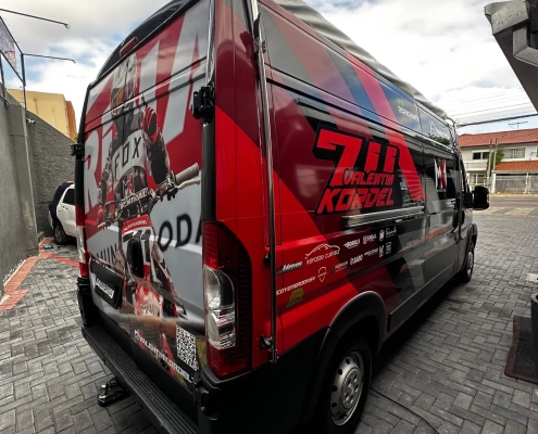 Van envelopada com tema do piloto Valentin Kordel em vermelho e preto