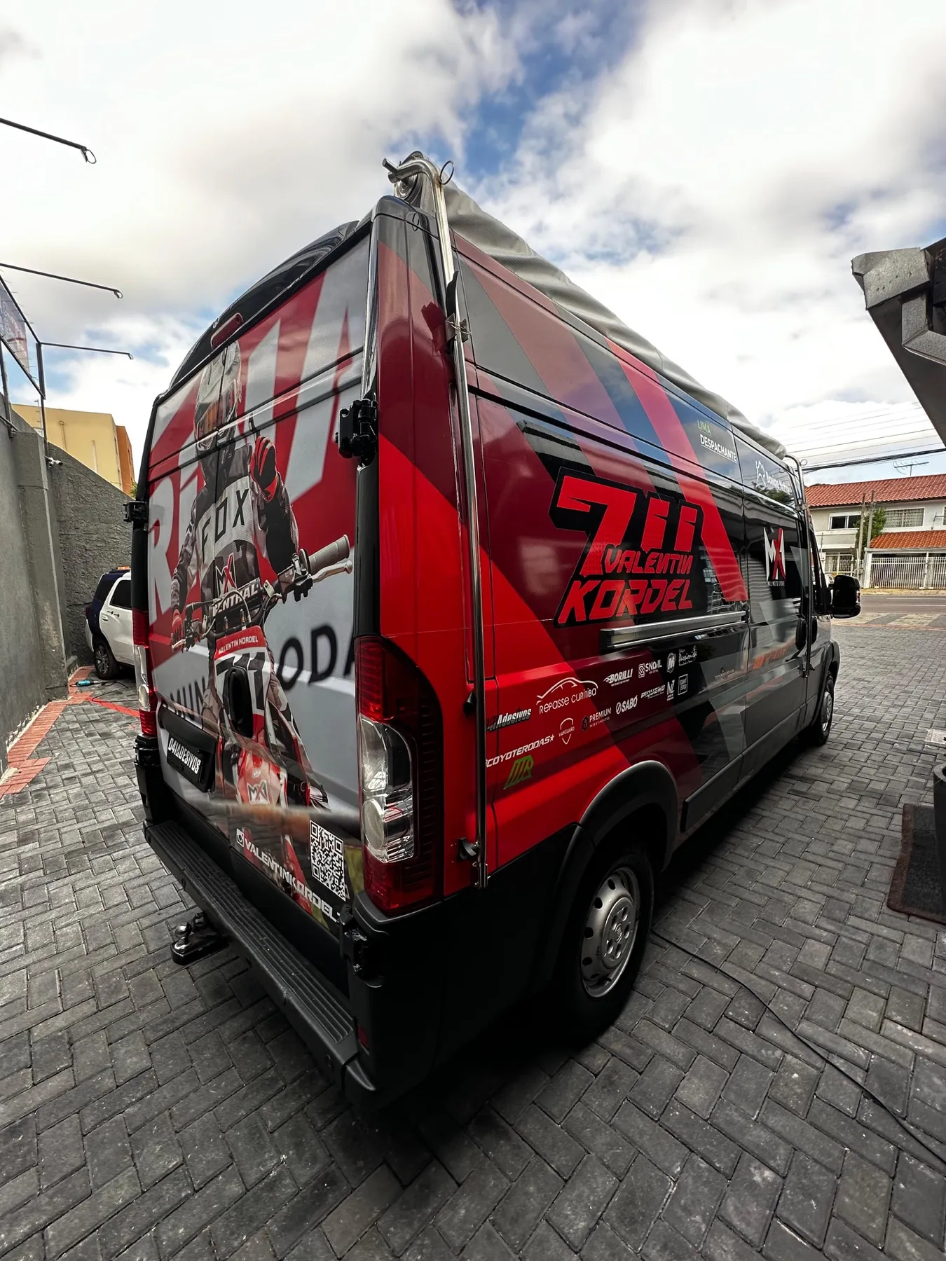 Van envelopada com tema do piloto Valentin Kordel em vermelho e preto