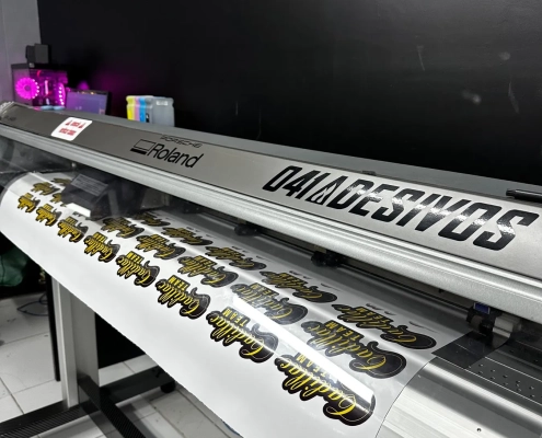 Plotter Roland imprimindo adesivos na produção da 041 Adesivos