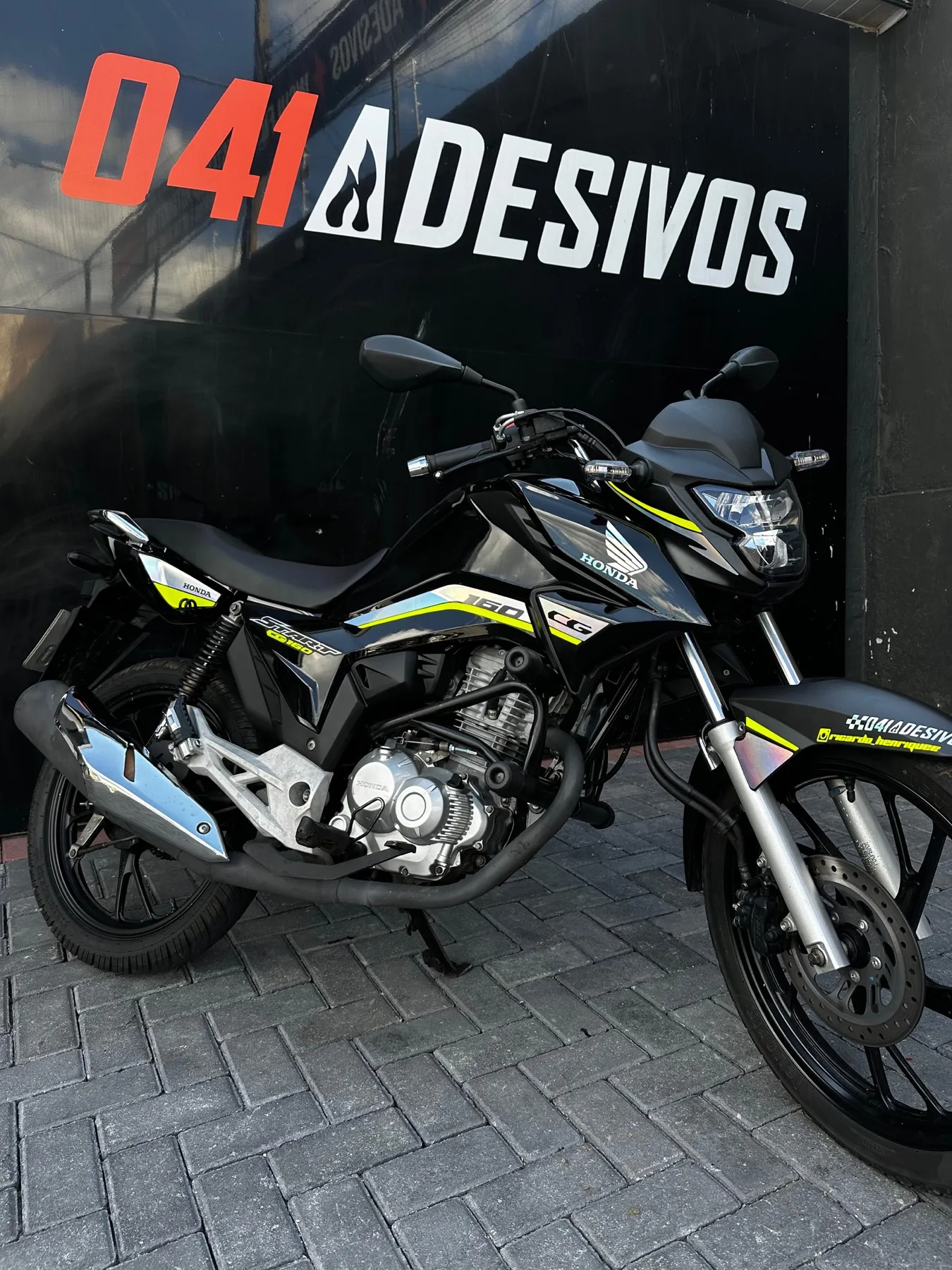 Honda CG 160 preta personalizada em frente à loja 041 Adesivos