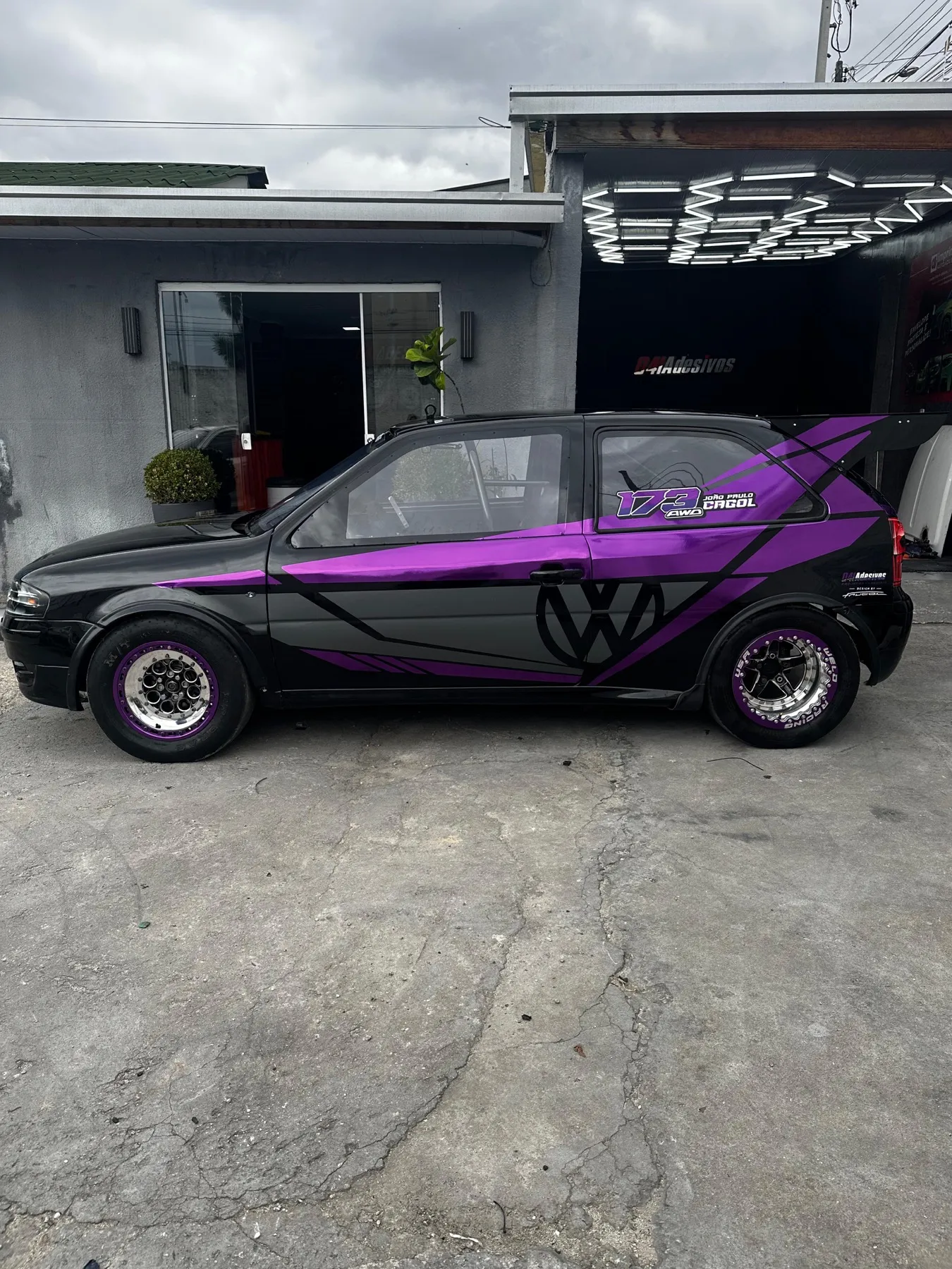 VW Gol envelopado preto com grafismos roxos e rodas raiadas
