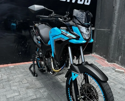 Moto trail Honda azul claro com adesivagem nas rodas