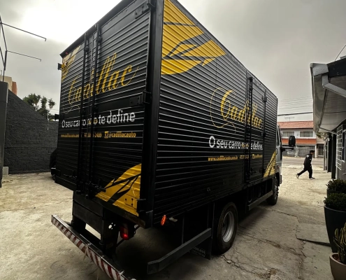 Caminhão baú preto envelopado Cadillac com grafismos amarelos