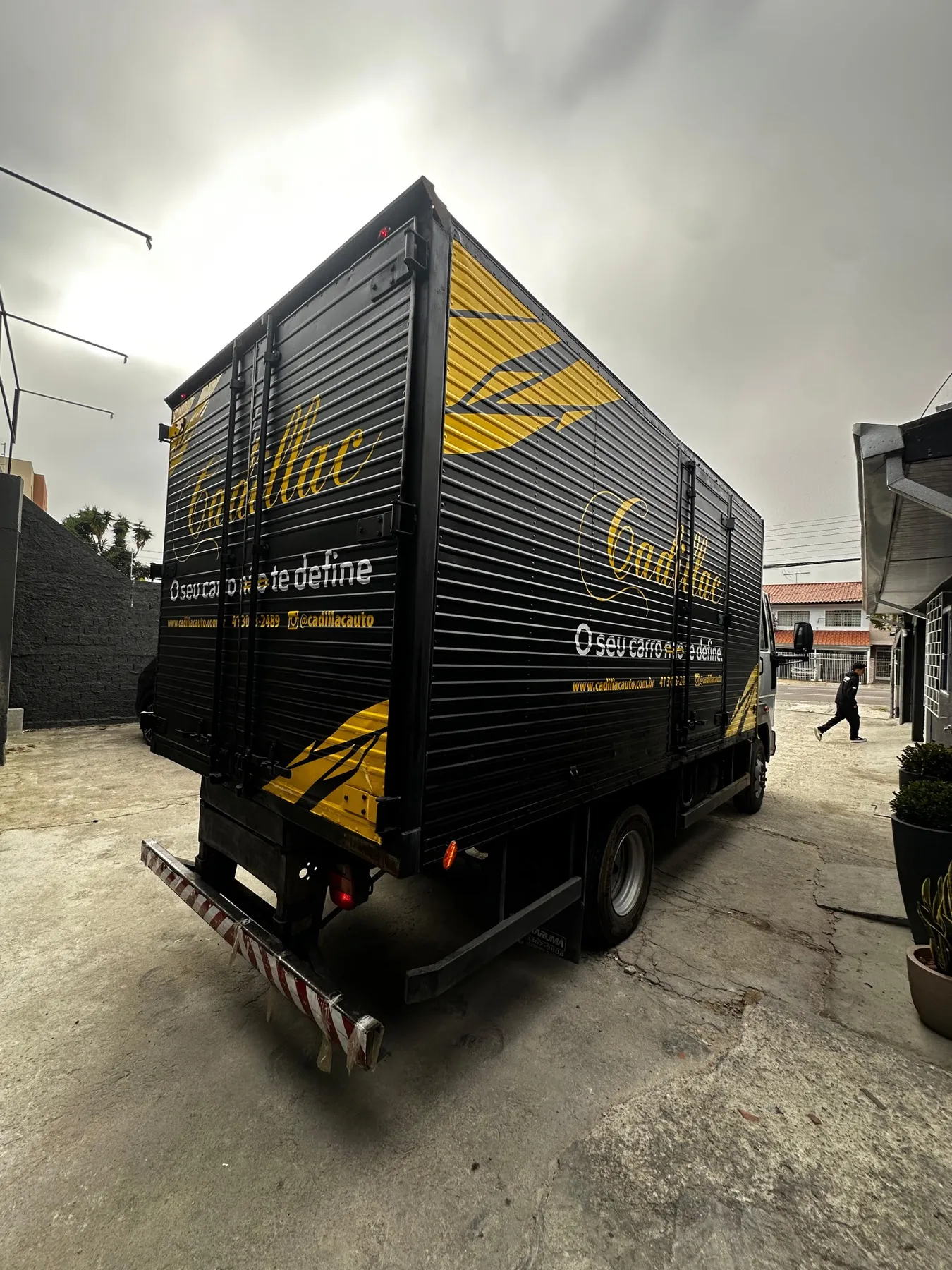Caminhão baú preto envelopado Cadillac com grafismos amarelos