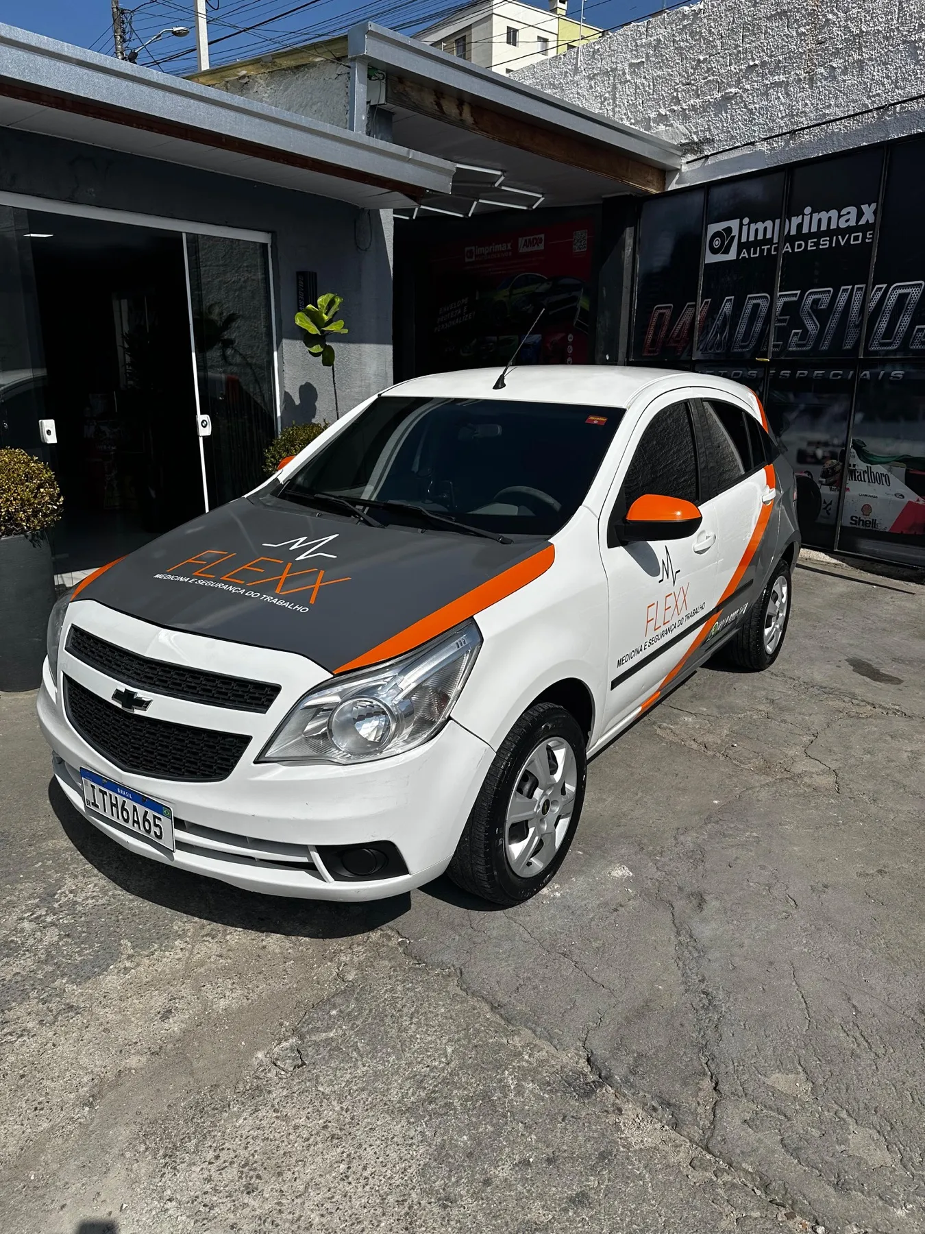 Traseira de Chevrolet Agile Flexx com logo e contato