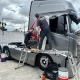 Equipe aplicando película em cavalo mecânico Volvo FH cinza