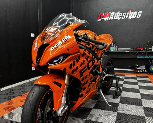 Moto esportiva laranja envelopada estilo corrida na loja