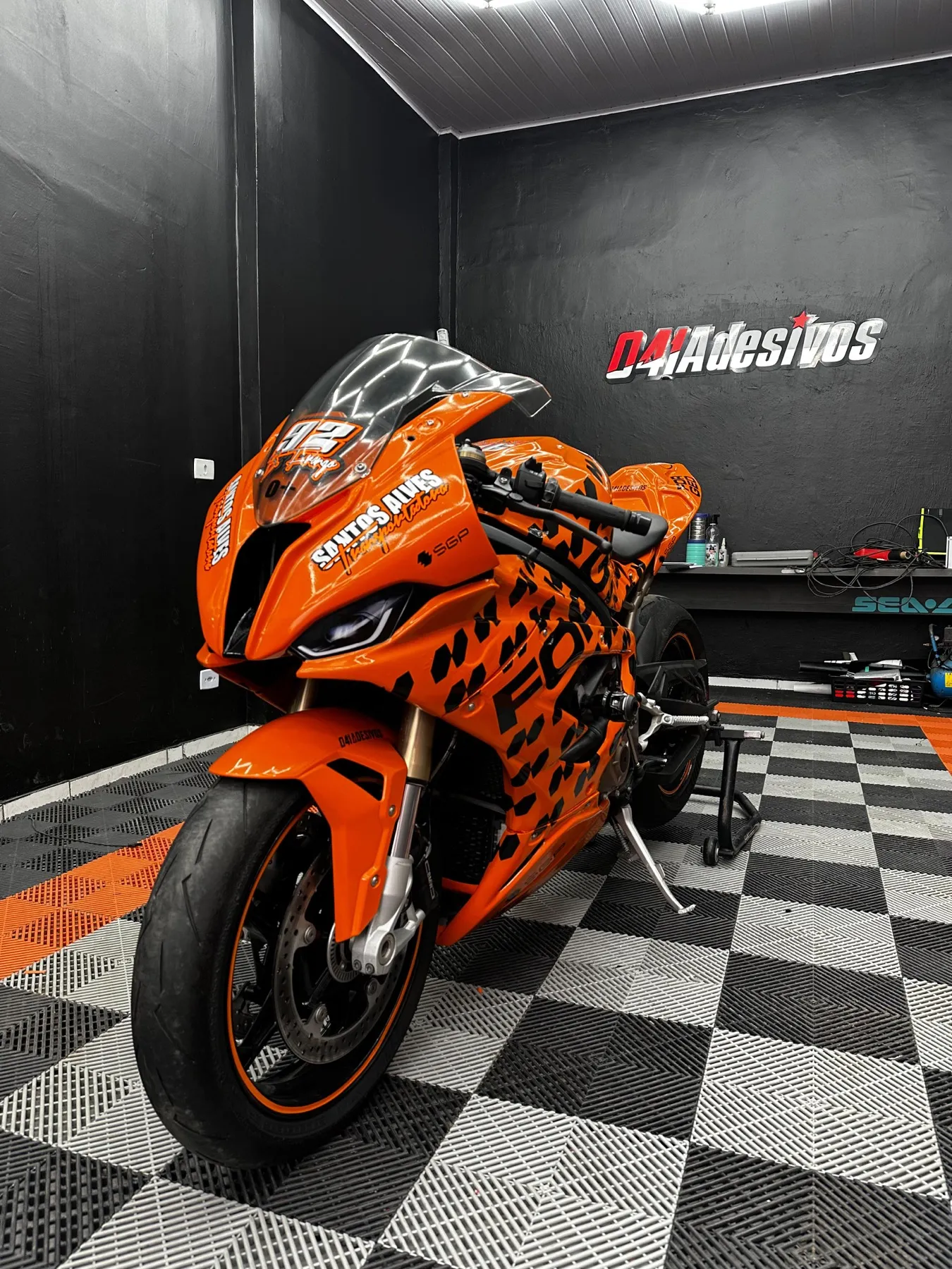 Moto esportiva laranja envelopada estilo corrida na loja