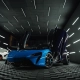 McLaren Artura azul com portas borboleta em estúdio escuro