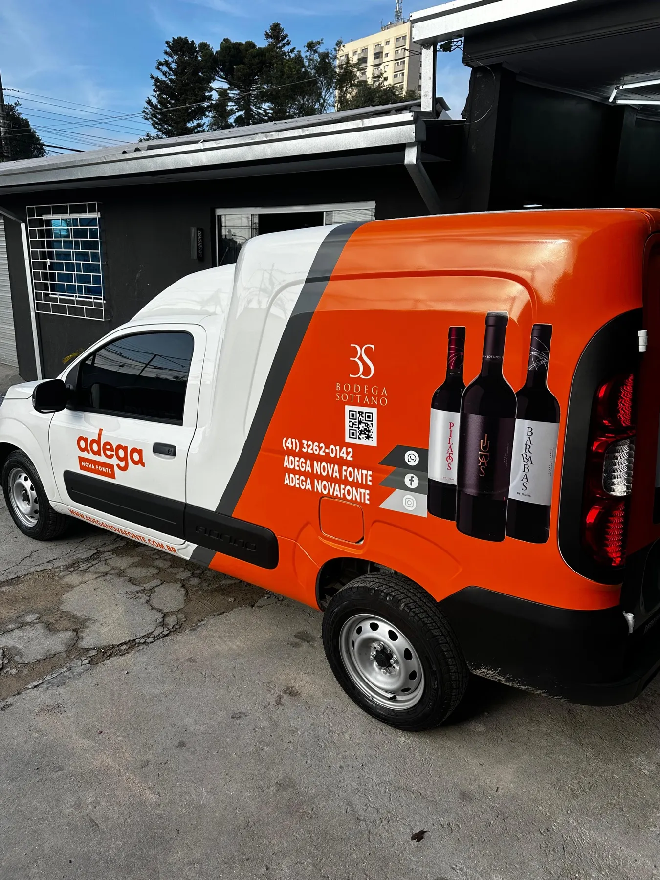 Fiorino branca da Adega Nova Fonte plotada em laranja com garrafas de vinho