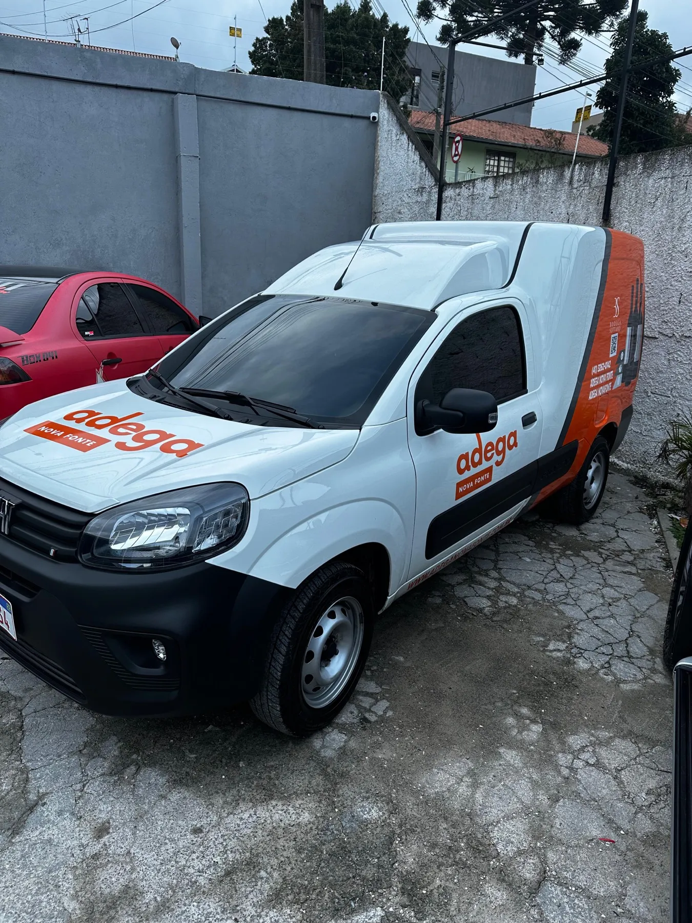 Fiat Fiorino branca da Adega Nova Fonte com envelopamento parcial laranja