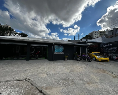 Fachada da loja 041 Adesivos com pátio, motos e carro esportivo