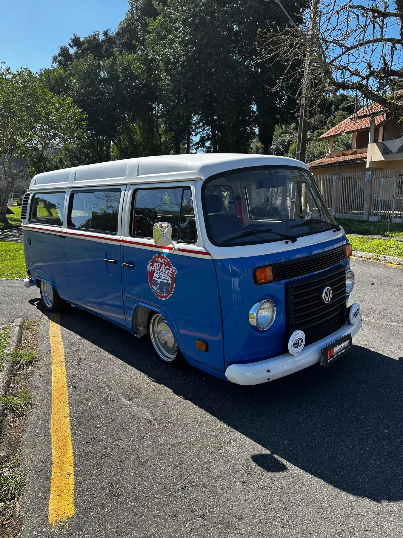 Kombi VW azul e branca rebaixada com adesivo garage retrô