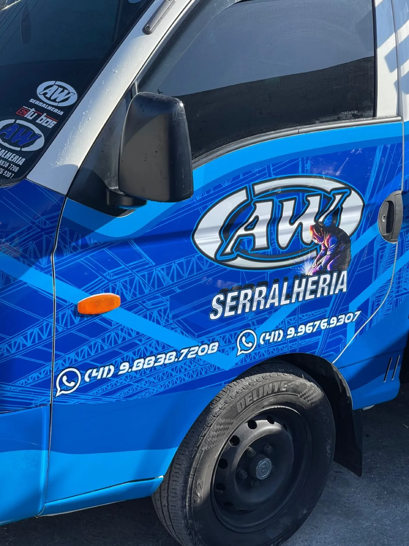 Mini caminhão azul plotado para AW Serralheria com contatos