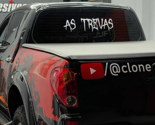 Picape preta com grafismo vermelho temático e letreiro As Trevas