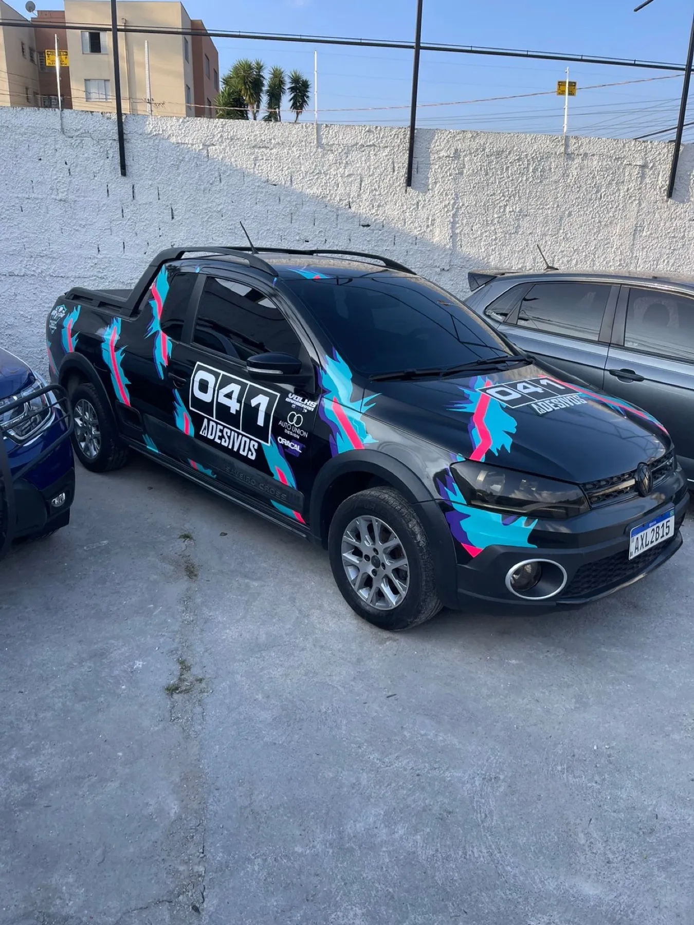 Volkswagen Saveiro preta com grafismo colorido e marca 041