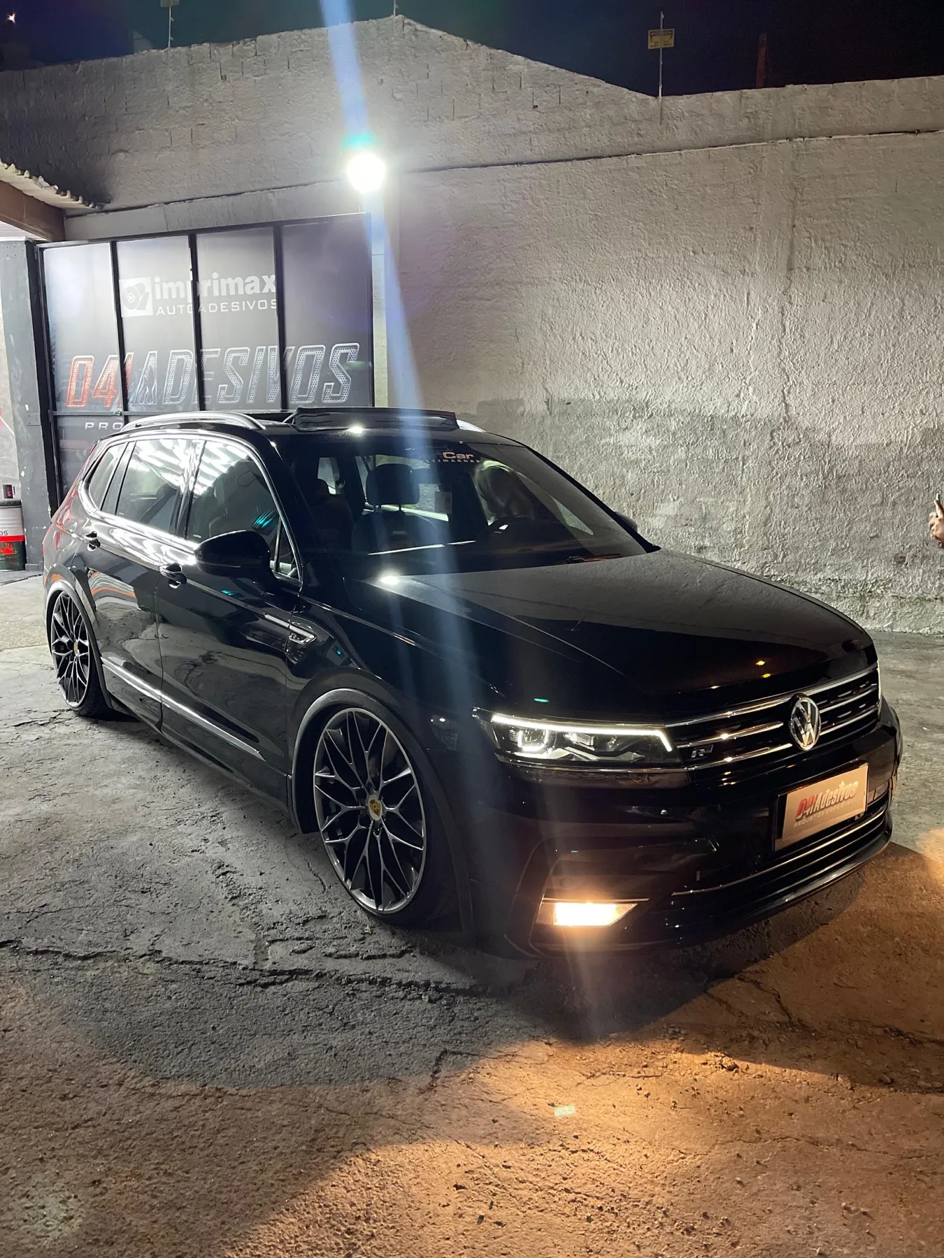 Volkswagen Tiguan R-Line preta rebaixada na loja à noite