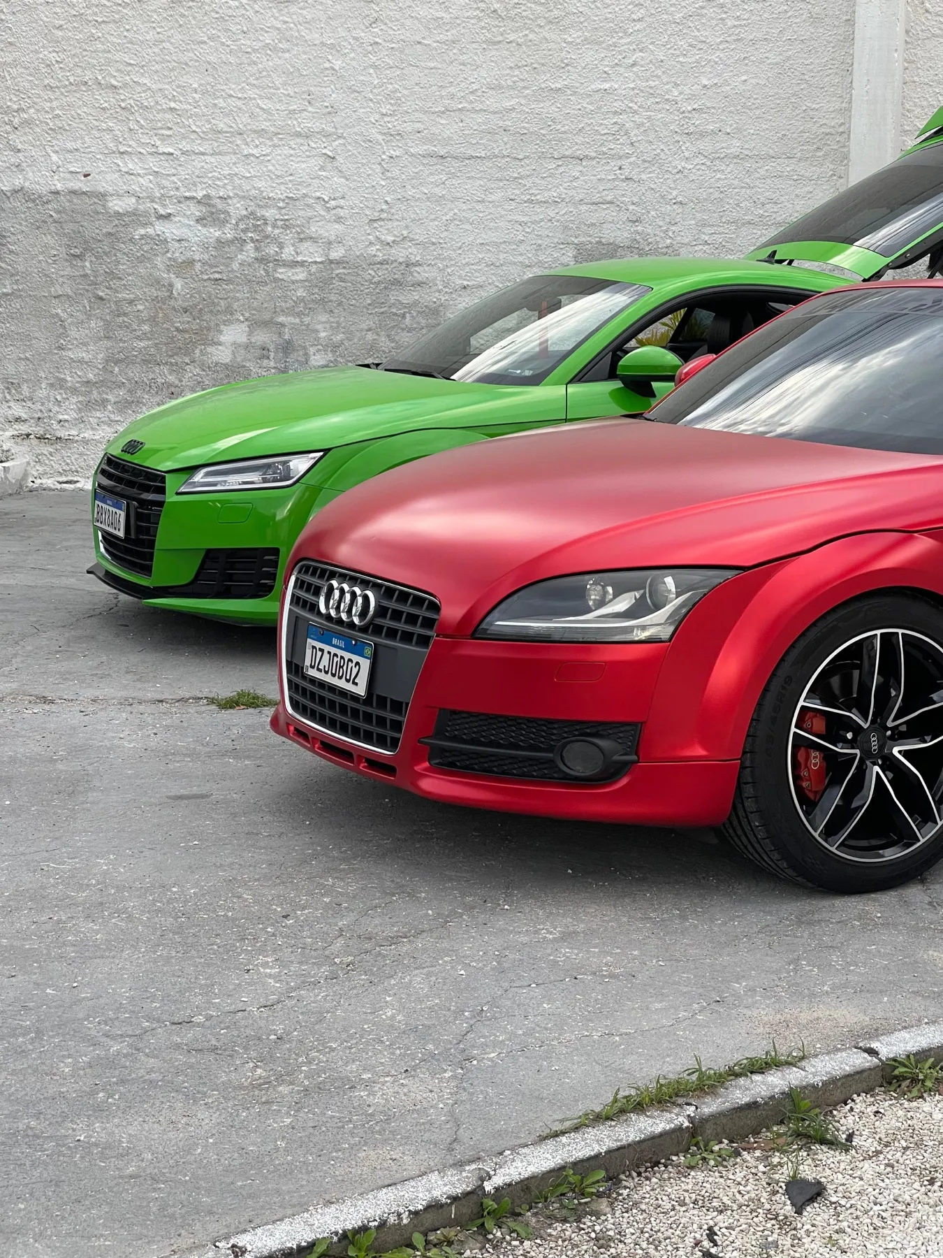 Dois Audi TT envelopados, verde-limão e vermelho fosco