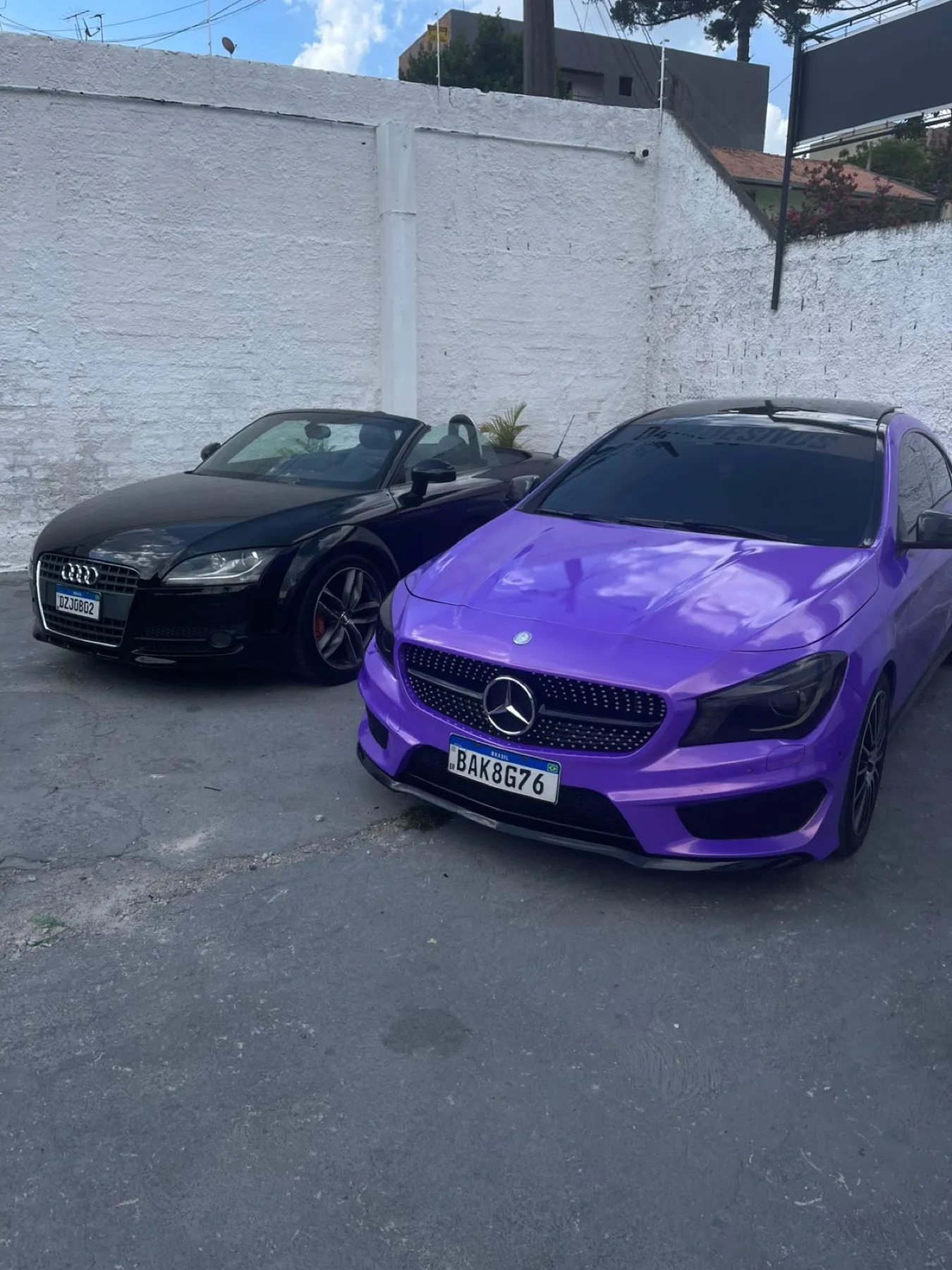 Mercedes-Benz CLA roxo metálico ao lado de Audi TT preto