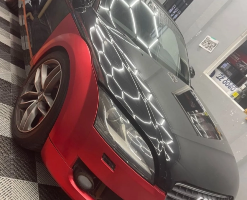 Audi TT bicolor preto fosco e vermelho metálico na loja