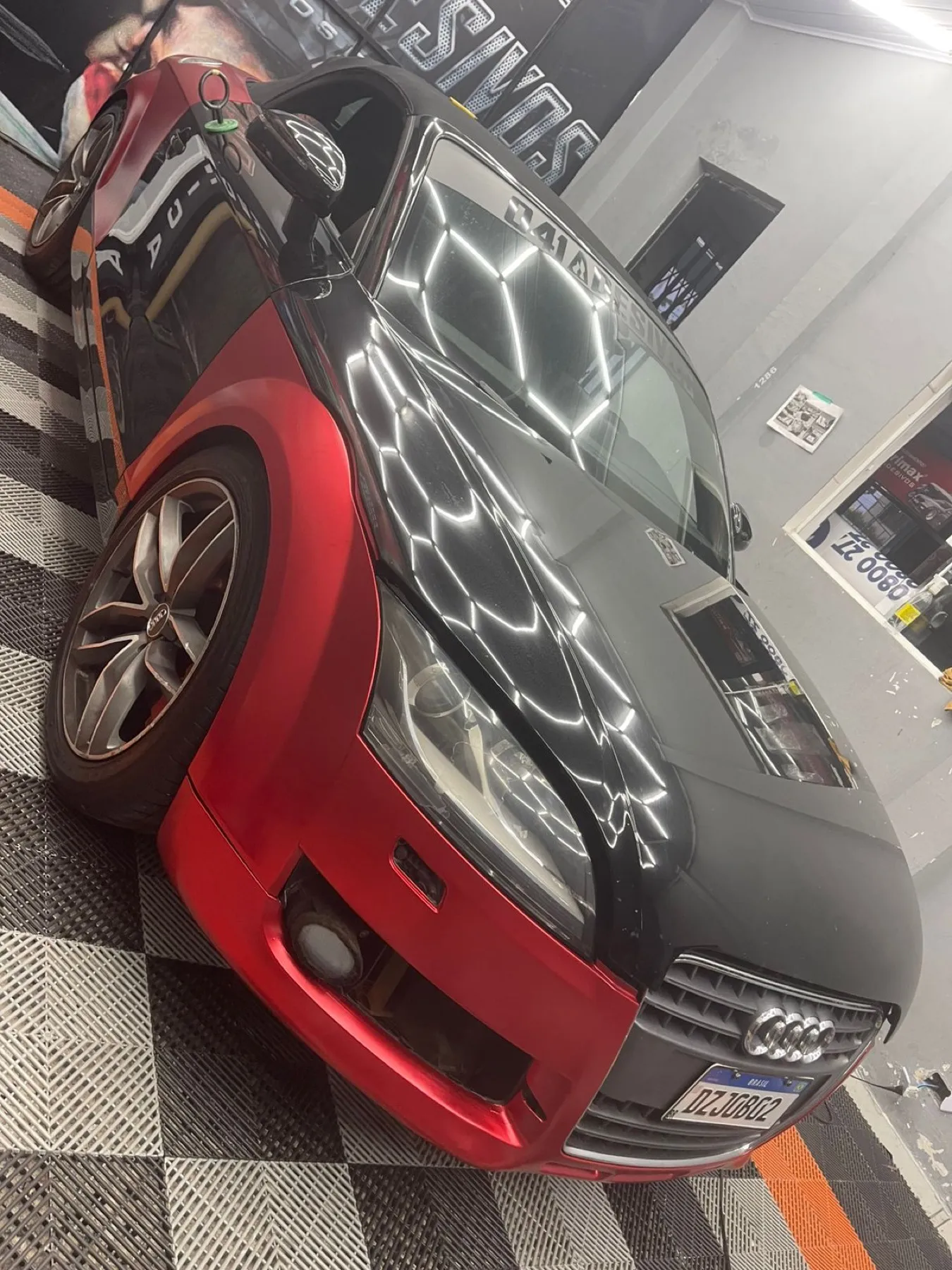 Audi TT bicolor preto fosco e vermelho metálico na loja
