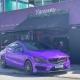 Mercedes-Benz CLA roxo cromado em frente a confeitaria
