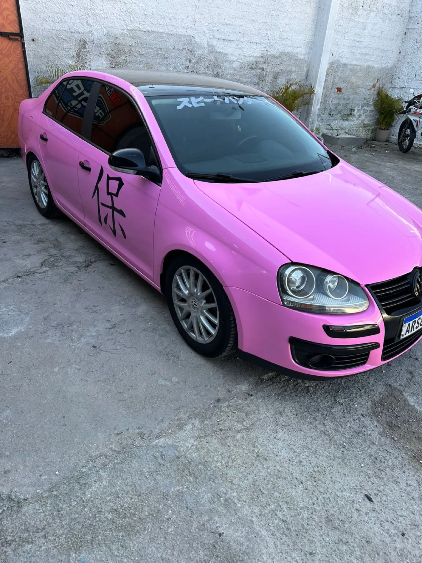 VW Jetta rosa envelopado, vista lateral com recorte kanji