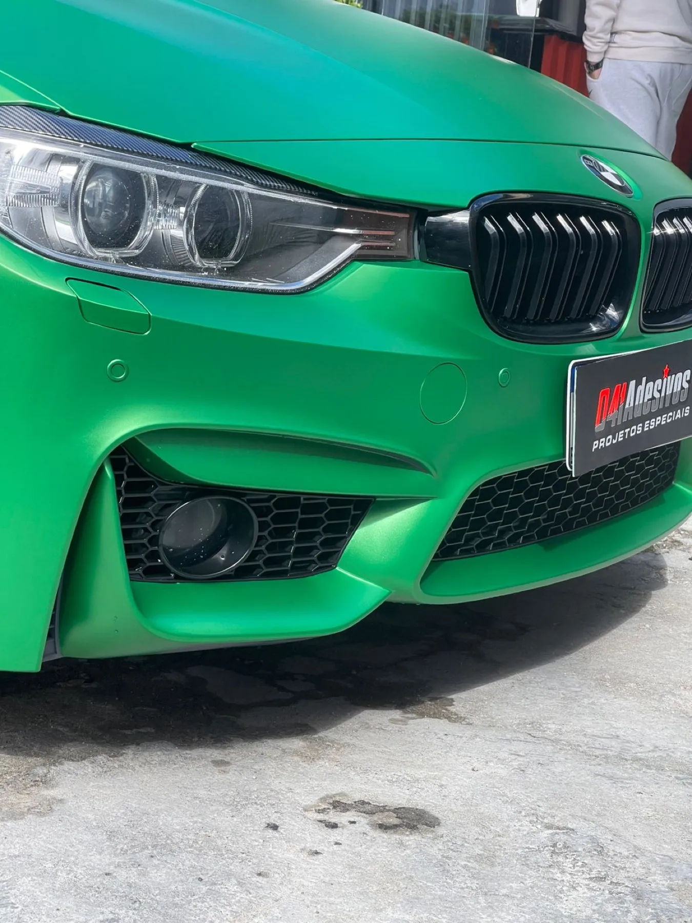 Detalhe da dianteira do BMW verde envelopado pela 041 Adesivos