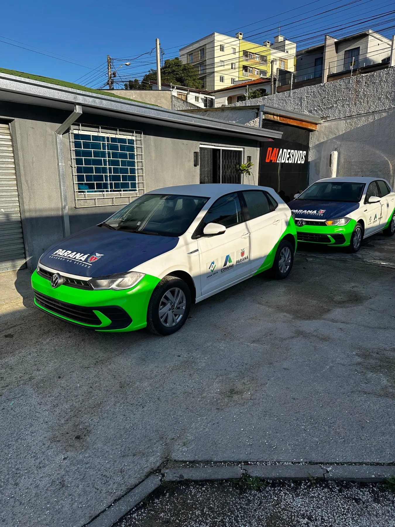 Dois VW Polo de frota do Paraná em frente à 041 Adesivos