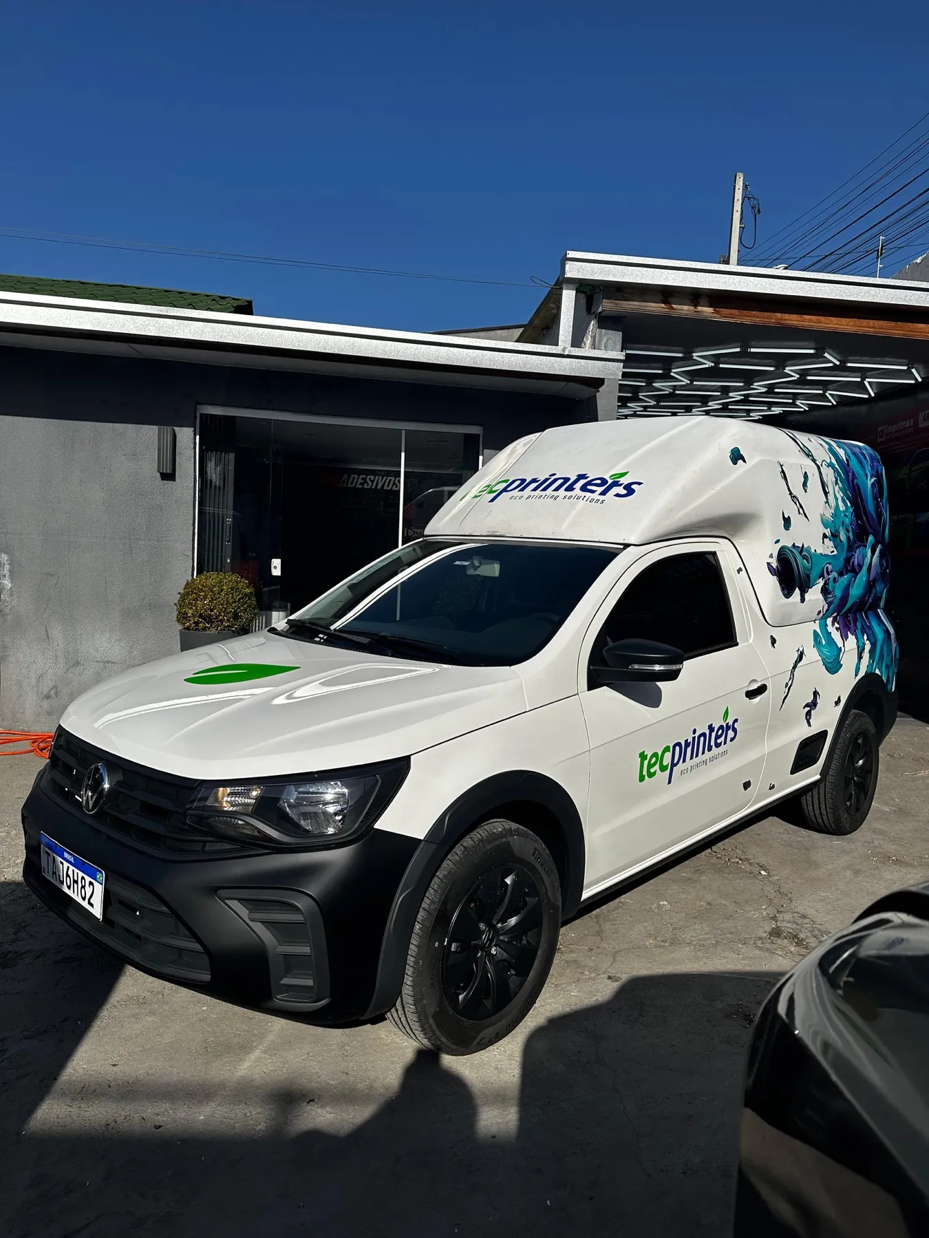 VW Saveiro branca plotada Tecprinters com arte de respingos azuis