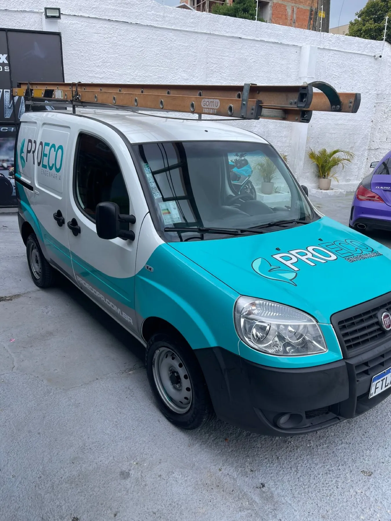 Fiat Doblò ProEco teal e branca com onda na lateral