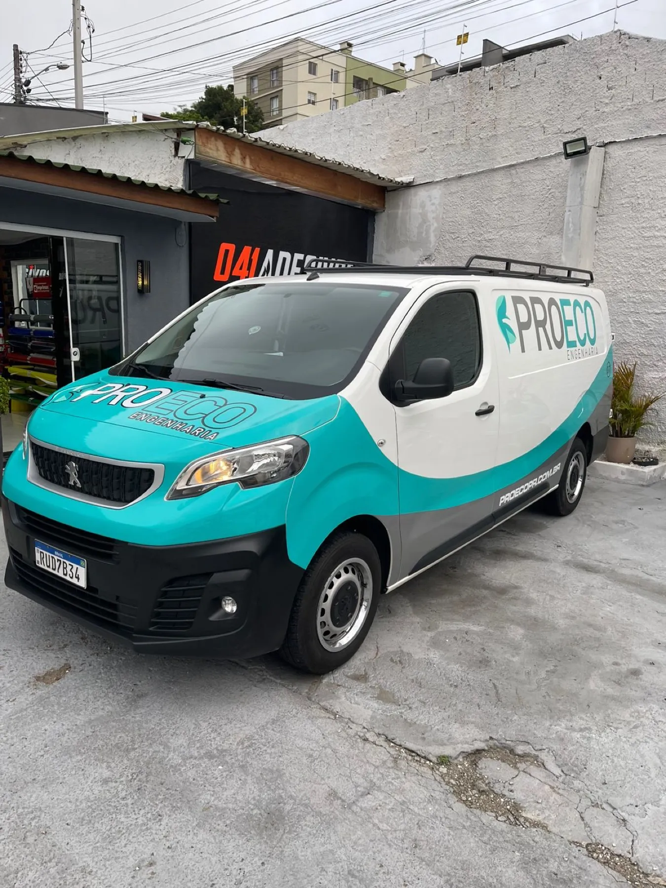 Peugeot Expert ProEco teal e branca em frente à loja 041