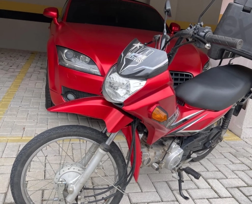 Honda NXR Bros vermelha estacionada em garagem