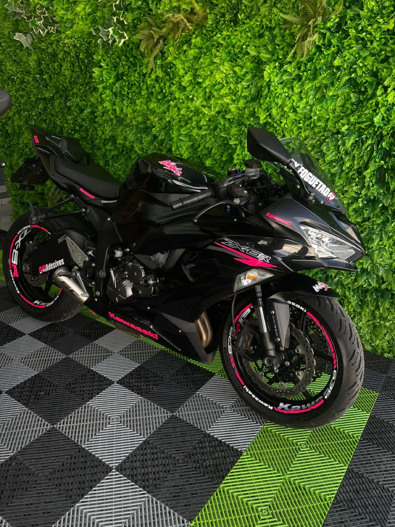 Honda trail preta e vermelha com adesivo no garfo