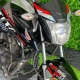 Yamaha grafite e laranja ao lado de mini moto na loja