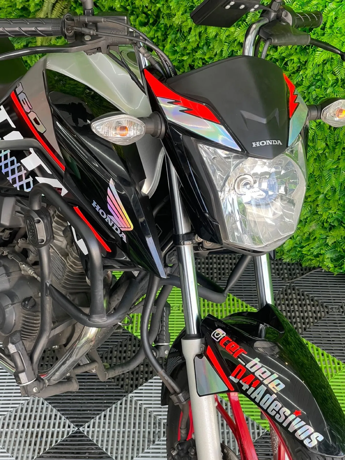 Yamaha grafite e laranja ao lado de mini moto na loja